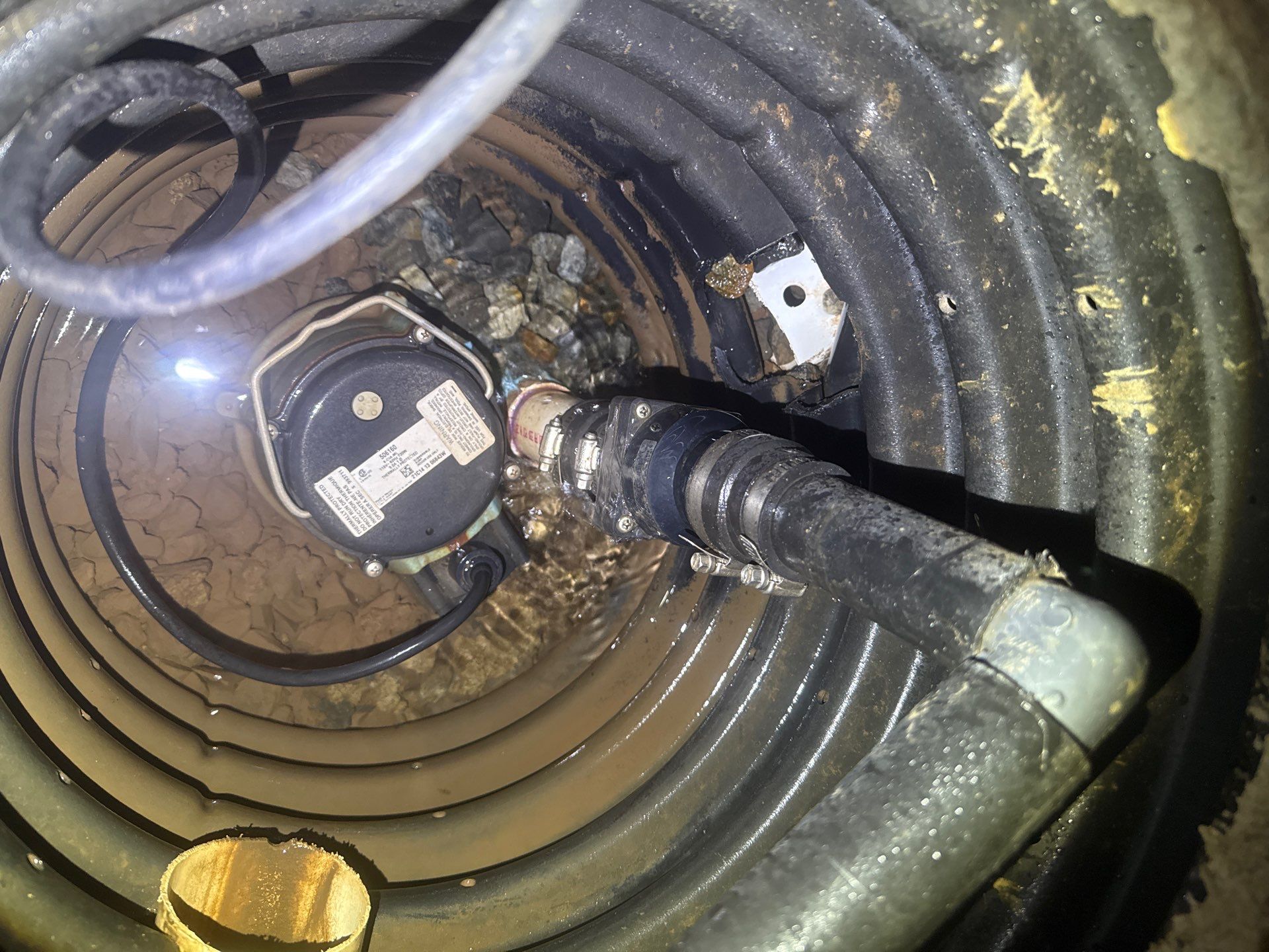 Sump pump and discharge pipe in basement sump pit, preventing basement flood.
